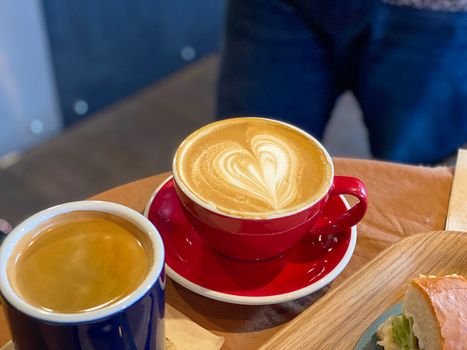 Two cups of coffee with latte art on wooden table