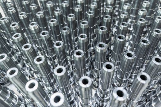 Shiny long steel parts full frame background, clean steel threaded rods after fine cnc turning.