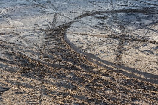 dry sand and mud ground with many dirt bike tracks at daylight.