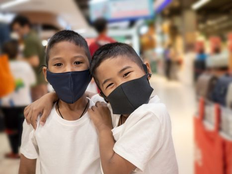 Two boy wearing a protective mask While in the mall.