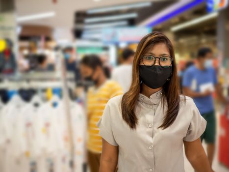 A woman wearing a protective mask While walking in the mall.