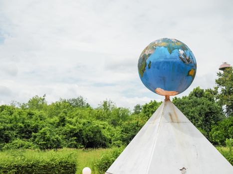 A model globe is placed on a triangular platform.