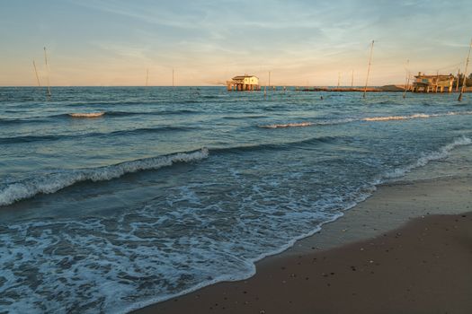 Fishing huts with typical italian fishing machine called "trabucco",at wonderful sunset ,Lido di Dante, fiumi uniti Ravenna near Comacchio valley.