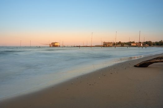 Fishing huts with typical italian fishing machine called "trabucco",at wonderful sunset ,long exposure photo,Lido di Dante, fiumi uniti Ravenna near Comacchio valley.