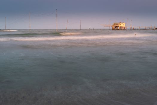 Fishing hut with typical italian fishing machine called "trabucco",at sunset ,long exposure photo,Lido di Dante, fiumi uniti Ravenna near Comacchio valley.