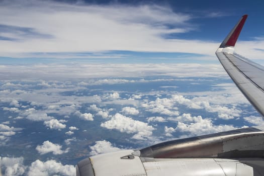 Flight and view over Bangkok in Thailand with clouds and city panorama in airplane.