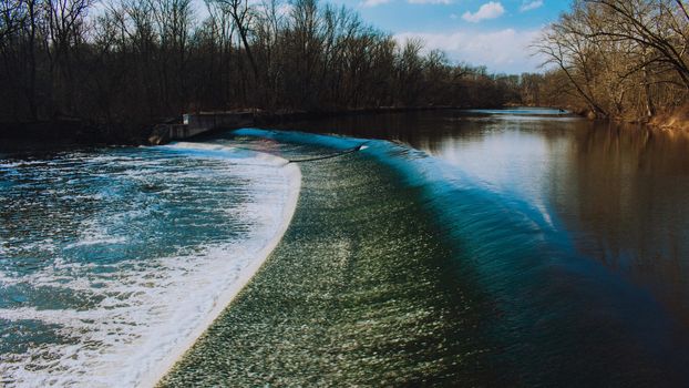 Fast Flowing Water Crashing Over a Man-Made Dam in a Dead Winter Forest