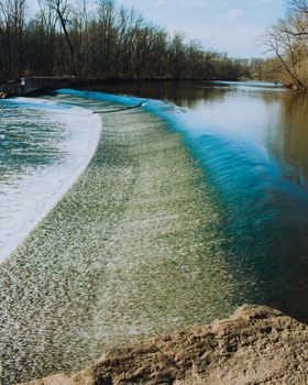 Fast Flowing Water Crashing Over a Man-Made Dam in a Dead Winter Forest