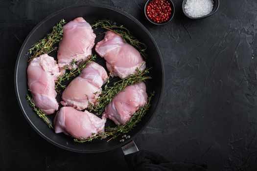 Raw chicken meat on pan on black backgroundtop viewwith space for text.