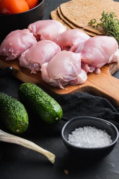 Shawarma ingredients, chicken thigh on black background with copy space.