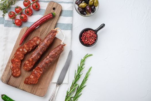 Traditional chorizo cuts with spices and ingredients on white textured background with space for text.