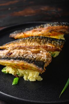Dish of marinated mackerel with garlic paprika and saffron.with softly mashed potatoes on dark wooden table.