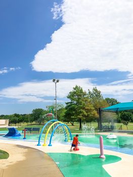 Colorful splash park with shaded picnic areas near Dallas, Texas, America. Recreation site with splashing water fountains for kids summertime activities