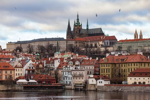 Beautiful view of Prague Castle and St. Vitus Cathedral located in Mala Strana old district on the Vltava river side of Prague on winter day with blue sky cloud,  Czech Republic