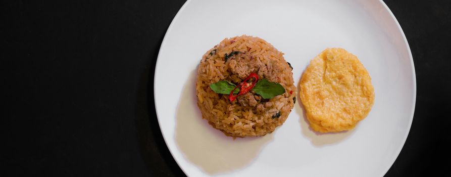 Basil pork fried rice and omelet egg on black background, Thai food, Street food, Image from the top view