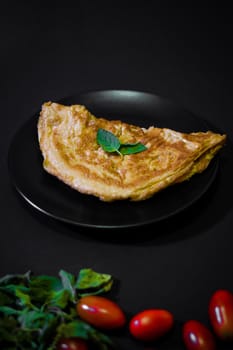Picture of an appetizing yellow omelette on a black background There is space to put text. Street food, Image from the top view