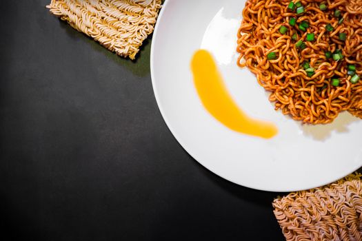 Korean spicy hot instant noodles on a black background, picture from the top view of instant noodles