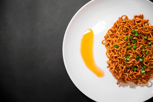 Korean spicy hot instant noodles on a black background, picture from the top view of instant noodles