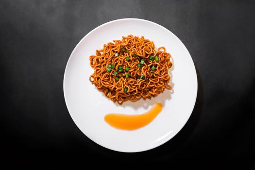 Korean spicy hot instant noodles on a black background, picture from the top view of instant noodles