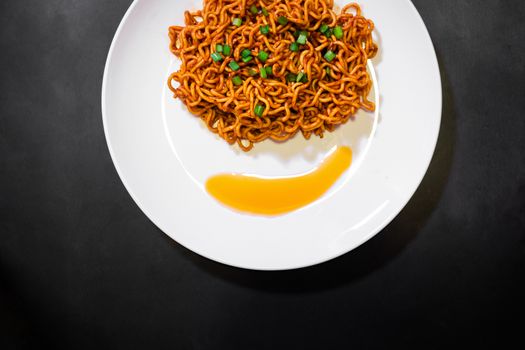 Korean spicy hot instant noodles on a black background, picture from the top view of instant noodles