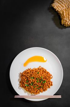 Korean spicy hot instant noodles on a black background, picture from the top view of instant noodles