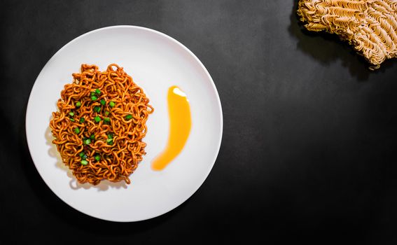 Korean spicy hot instant noodles on a black background, picture from the top view of instant noodles