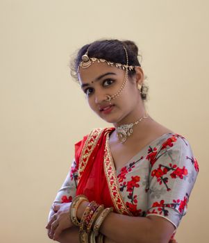 A beautiful young Hindu girl with gold ornaments according to her traditions and customs and red lipstick on her attractive soft lips