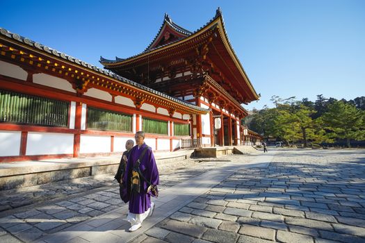 Nara, Japan - December 16, 2019 : Japanese monks are walking pass the second Wooden gate Of Todaiji Temple, this is the most famous travel destinations of Nara city in Kansai area of Japan.