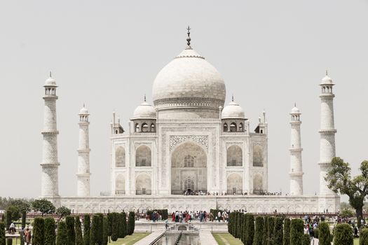 Many visitors to the Taj Mahal in Agra, India. Mogul marble mausoleum with minarets, mosque and symmetrical gardens.