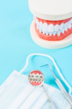 Focus white healthy teeth in mirror of dental equipment with model teeth, Dental concept.