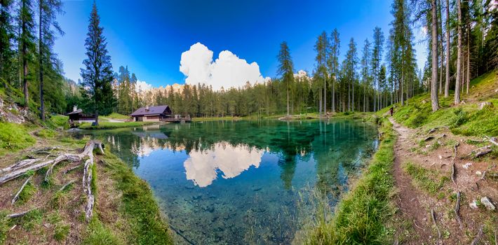 Beautiful chalet by the lake, mountain landscape panorama.