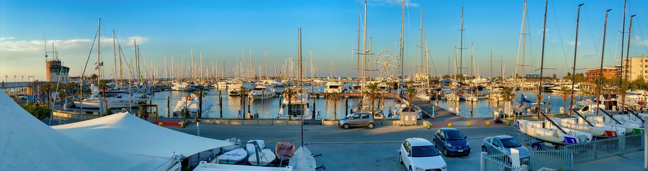 RIMINI, ITALY - AUGUST 26, 2020: Sunset view of city port and boats.