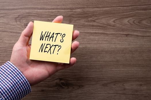 Hand holding notepad with text What's Next? Conceptual Image