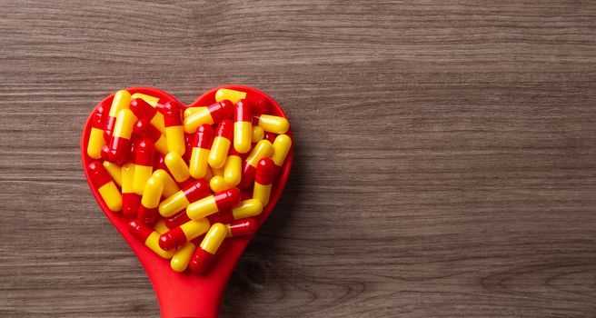 Pill on love shape spoon. health care conceptual