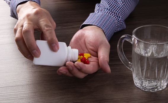 close up of senior man hand taking pills