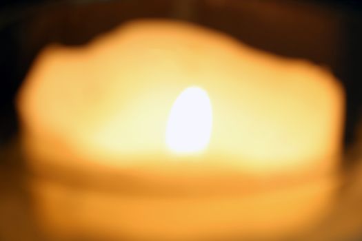 Burning candle on dark background.Out of focus. Symbol of sorrow