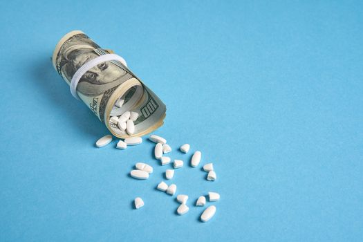 pills empty blisters for drugs individual syringe and money lie on a blue background Expensive medicine health insurance concept. Expensive treatment of diseases. Budget for medical expenses poured