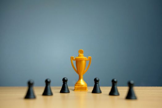 Golden trophy in the middle of chess pawn