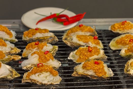 Street food asia. Grilled seafood. Oysters on the grill