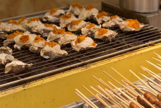 Street food asia. Grilled seafood. Oysters on the grill. Chinese street food