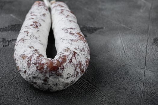 Dry cure salami sausage fuet on grey background with space for text.