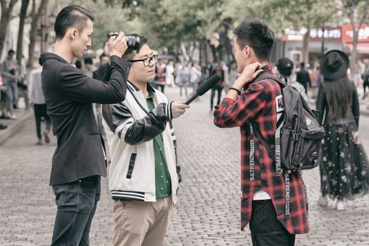 Harbin, Heilongjiang, China - September 2018: Filming interview. Blogger writes video report
