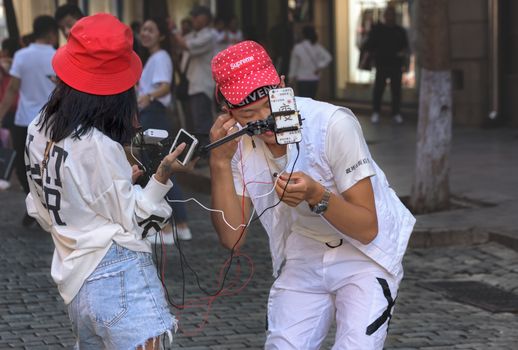 Harbin, Heilongjiang, China - September 2018: Young man and woman working as blogger. Blogger writes video report