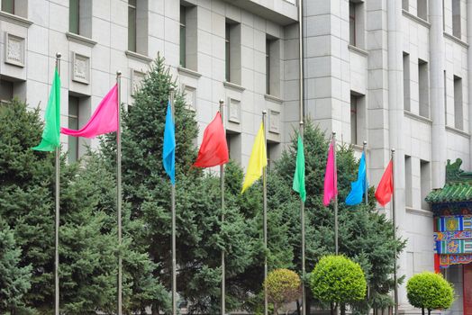 Colorful flags. Building facade and flags. Flagpoles