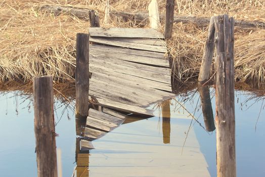 Broken wooden bridge. Water overflow on a broken wooden bridge