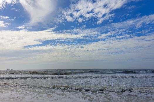 Muddy sea. Seascape and cloudy sky. Waves of muddy sea