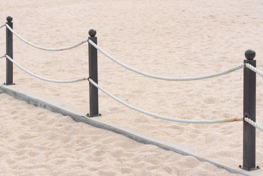 Rope fence on the sandy beach. Prohibition of passage