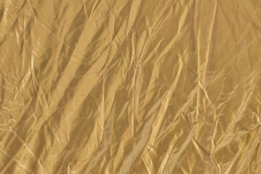 Golden textile background. Fabric of yellow color.