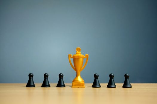 Golden trophy in the middle of chess pawn