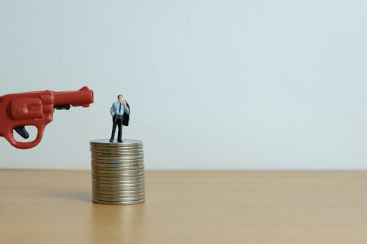 Miniature people concept - businessman thinking desperately for debt financial solution.